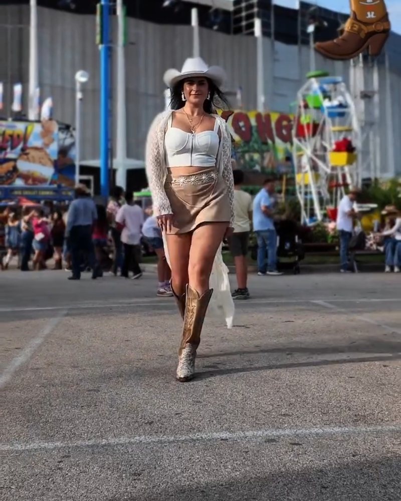Frau mit Cowboyhut und Boots auf einem Volksfest